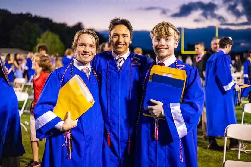 Students in blue robes graduate